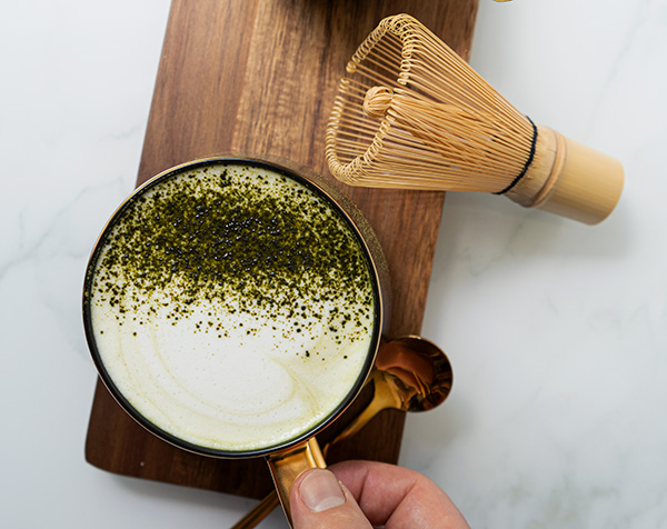 Prepared Fonte matcha latte with a bamboo whisk